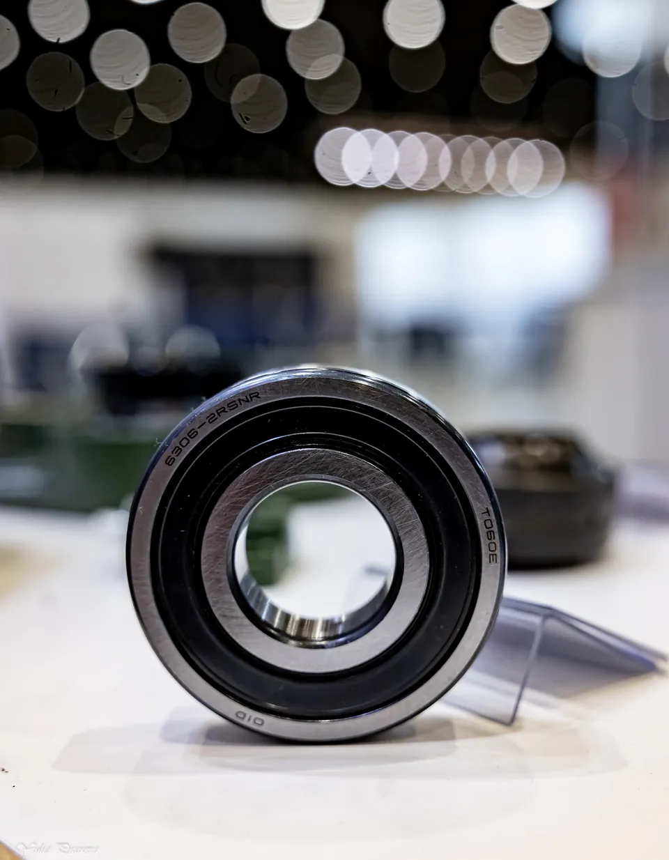 A bearing with a black seal on a clear stand