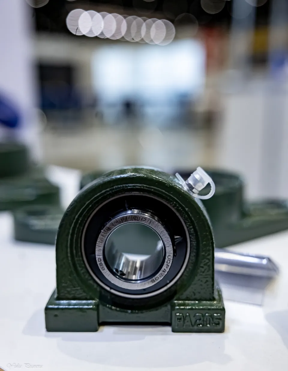 A bearing in a green housing on display