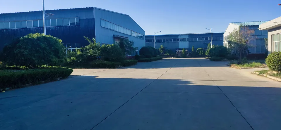 Factory grounds with the production building, access road and trees