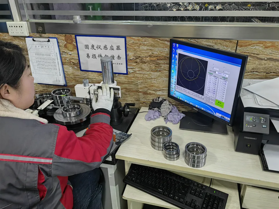 A specialist checking a part on measuring equipment with a computer readout